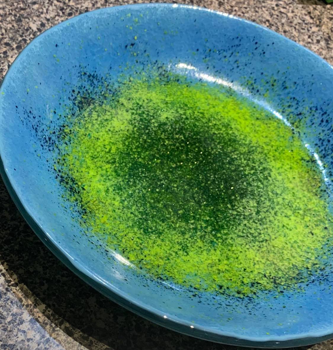 9" diameter shallow blue bowl with green shimmer in the center
