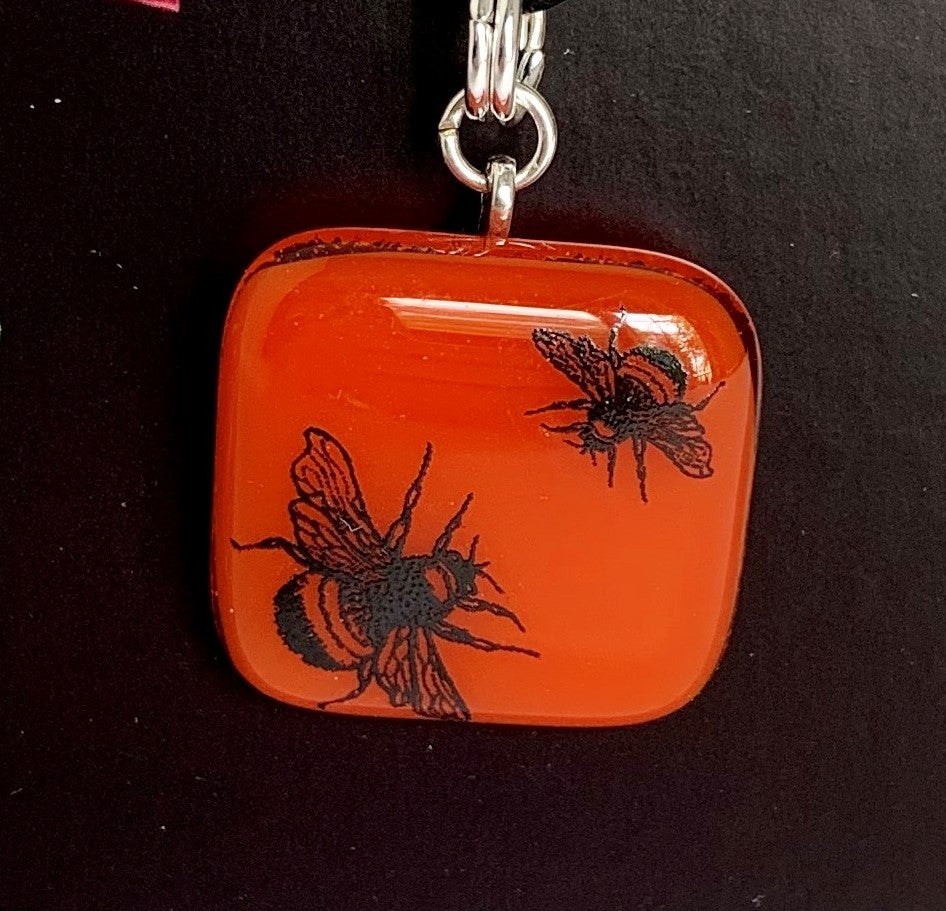 Orange pendant with playful bees